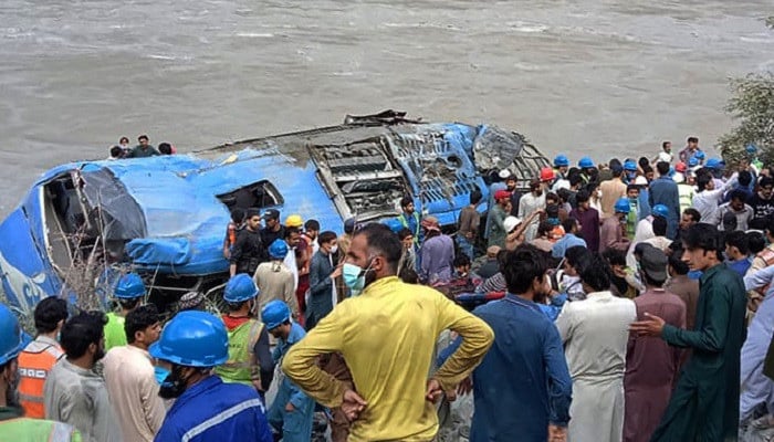 Rescue workers and onlookers gather around a wreck after a bus plunged into a ravine following a bomb explosion in Kohistan district of Khyber Pakhtunkhwa province on July 14, 2021. — AFP