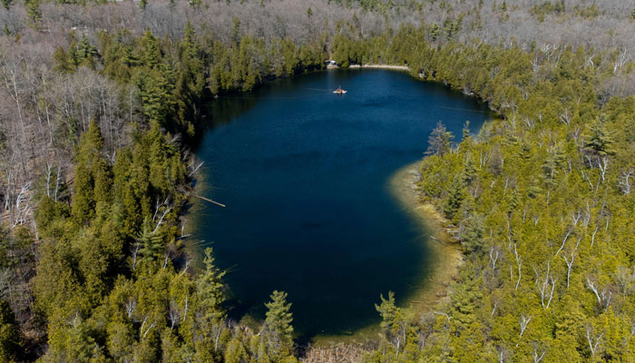 An aerial view of Crawford Lake as scientists from Carleton University and Brock University gather sediment layer samples from the lake bottom at the Crawford Lake Conservation Area near Milton, Ontario, Canada, April 12, 2023. — AFP