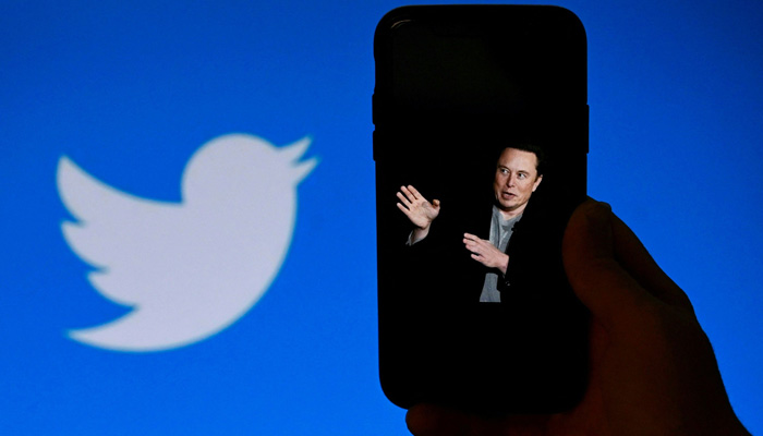 This picture shows a display of Elon Musk with the Twitter logo shown in the background, on October 4, 2022, in Washington, DC. — AFP
