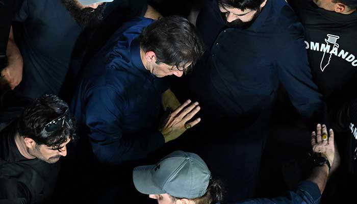 PTI Chairman Imran Khan being escorted by security personnel to a court in Lahore in this undated photo. — AFP/File