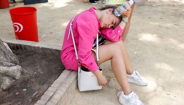 A woman cools herself with a water bottle during the first heatwave of the year in Seville, Spain June 11, 2022. — REUTERS