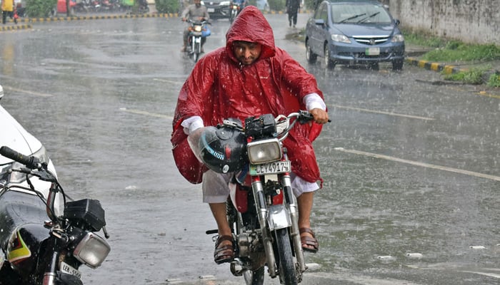 15 جولائی 2023 کو لاہور میں تیز بارش کے دوران موٹرسائیکل جا رہا ہے۔ — آن لائن