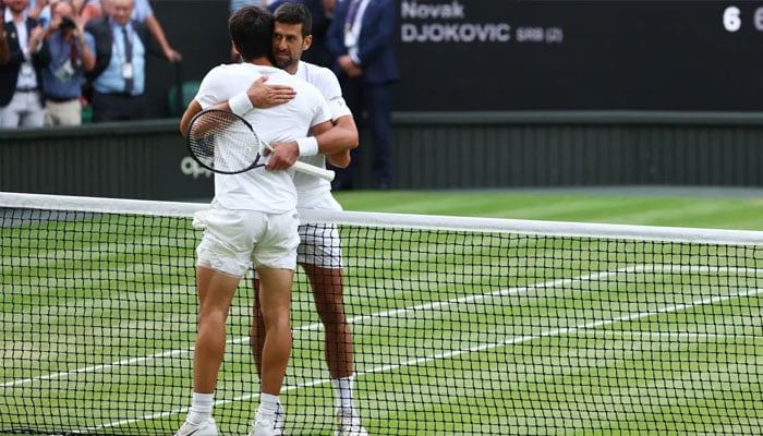 Carlos Alcaraz and Novak Djokovic hug after the Wimbledon final.—Reuters