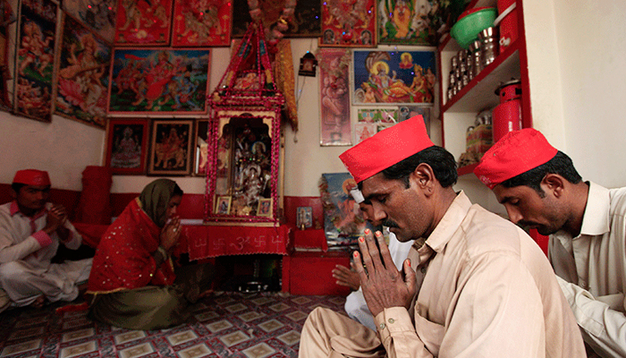 Image of Hindu devotees praying inside a temple. — Reuters