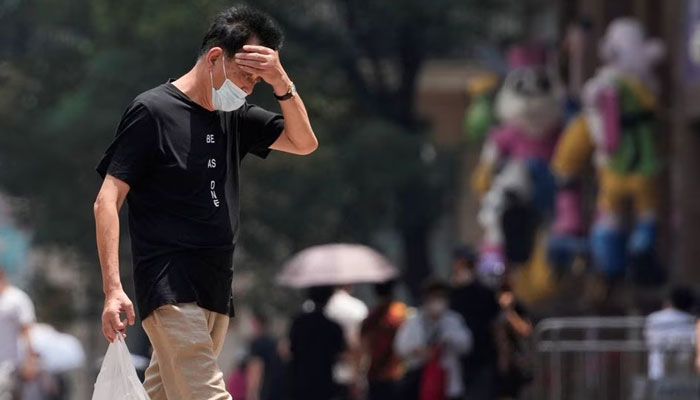 A man wearing a face mask reacts on a street amid a heatwave warning, in Shanghai, China July 13, 2022. — Reuters