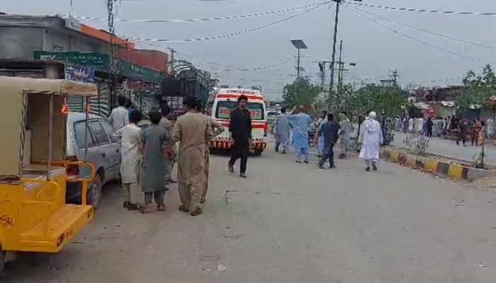 People can be seen walking on the road past an ambulance following an explosion in KPs Bara Bazar, on July 20, 2023, in this still taken from a video. — Reporter