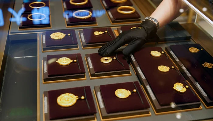 A salesperson poses with heritage gold jewellery at jeweller Chow Tai Fook’s retail store in Shanghai, China August 18, 2021. — Reuters