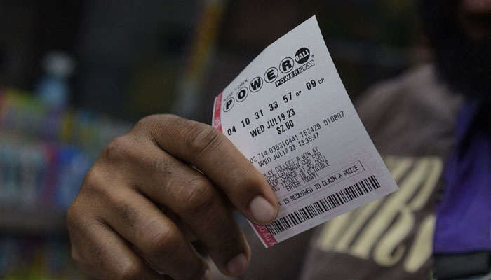 This representational picture shows a man holding a Powerball ticket. — AFP/File