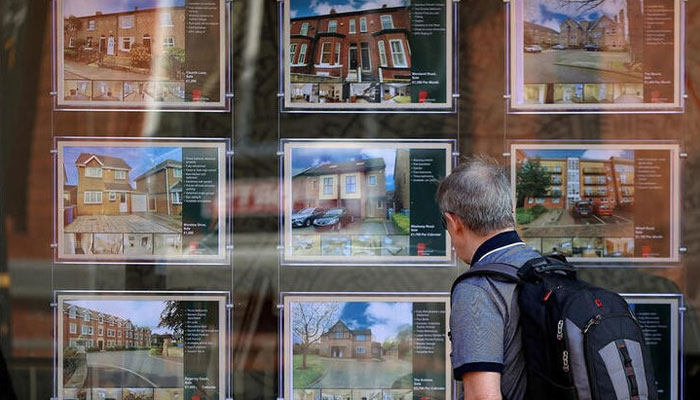 A man looks at houses for sale in the window of an estate agent in Manchester, Britain, June 22, 2023. — Reuters