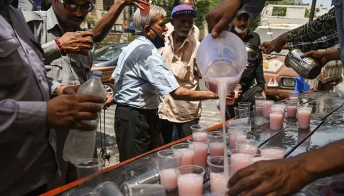 Volunteers distribute beverages to commuters as part of a free service on a hot summer afternoon in New Delhi on May 23, 2023. AFP/File