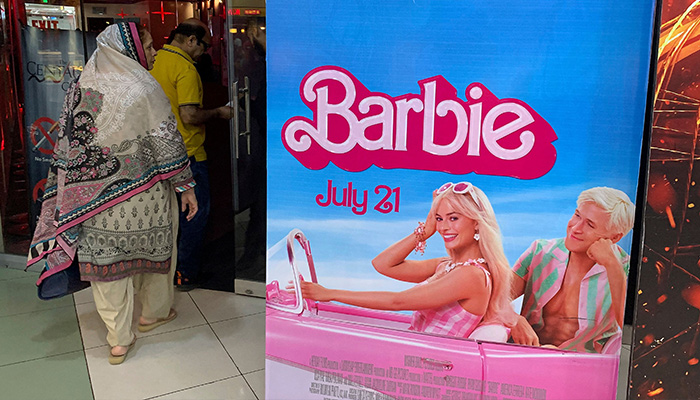 Moviegoers pass by a poster of the film Barbie at a Cineplex in Islamabad on July 21, 2023. - AFP