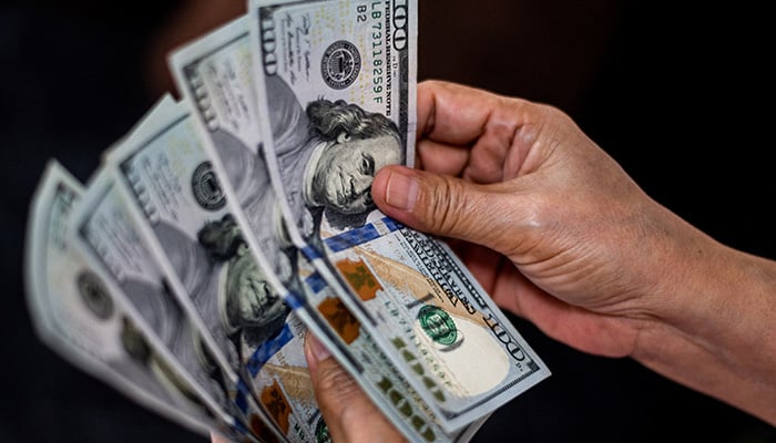 A person shows U.S. dollars at a currency exchange store in Manila, Philippines, October 21, 2022. — Reuters