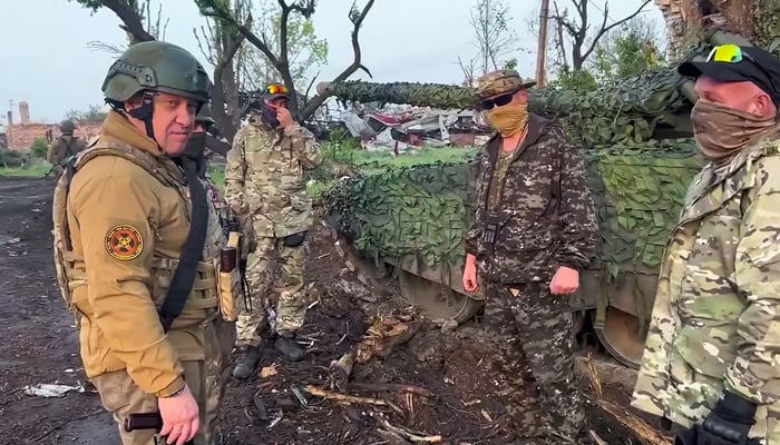 This video grab, taken from handout footage posted on May 25, 2023, shows Yevgeny Prigozhin (left) speaking to his fighters in Bakhmut. - AFP
