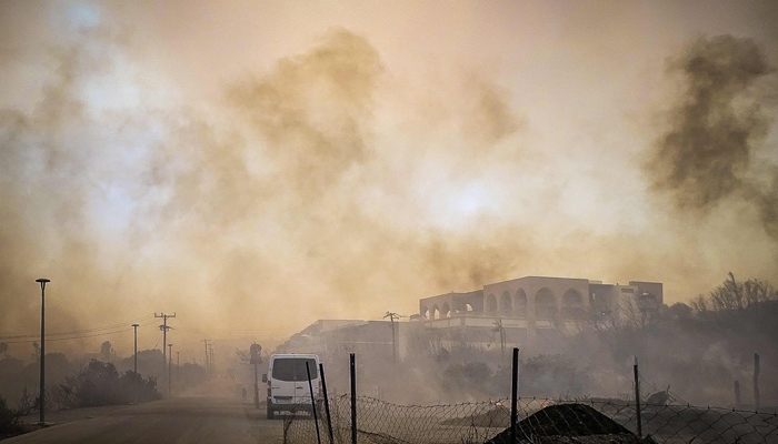 Αυτή η φωτογραφία που τραβήχτηκε στις 22 Ιουλίου 2023, δείχνει καπνό να αναδύεται από ένα καμένο ξενοδοχειακό συγκρότημα κατά τη διάρκεια μιας πυρκαγιάς στο ελληνικό νησί της Ρόδου.  — Γαλλικό Πρακτορείο