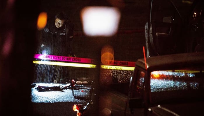 A police officer looks at the crime scene where one man was shot dead and five others were injured in Normandale Park in Portland, Oregon, US, according to the Portland Police Bureau. Reuters/File