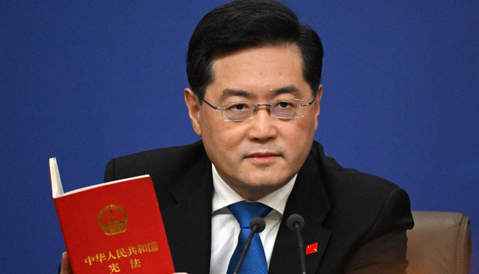 Chinas Foreign Minister Qin Gang holds a copy of Chinas constitution during a press conference at the Media Center of the National Peoples Congress (NPC) in Beijing on March 7, 2023. — AFP