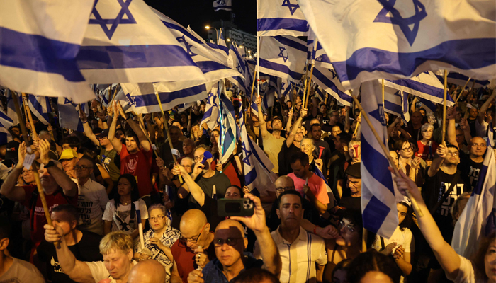 Demonstrators wave national flags during a rally to protest the Israeli government´s judicial overhaul plan, in Tel Aviv on June 24, 2023, — AFP