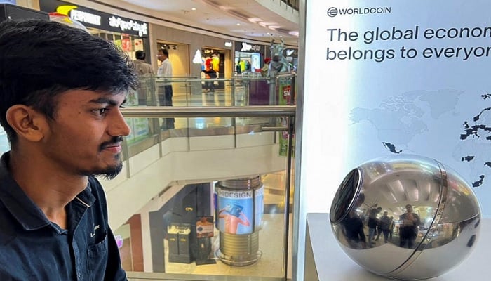 An man signs up for WorldCoin by having his eyes scanned by an “Orb” at a shopping mall in Bengaluru on Tuesday. — Reuters
