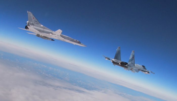 This video grab released by the Russian Defence Ministry on February 9, 2022, shows a Tupolev Tu-22M3 Backfire strategic bomber (L) and a Su-35 multirole supermaneuverable fighter flying during joint exercises of the armed forces of Russia and Belarus. — AFP