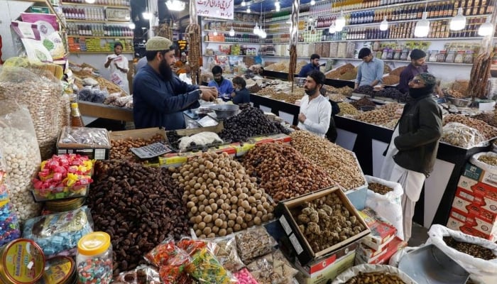 People buy dry fruits at a market in Karachi, February 1, 2023. — Reuters