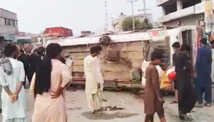 People gathered around the overturned bus after the accident in Rajanpur on July 30, 2023, in this still taken from a video. — Reporter