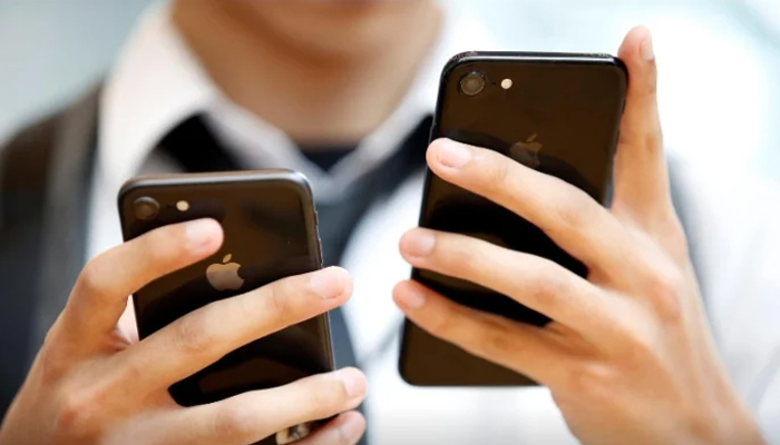 A man compares two models of the iPhone in this undated photo. — Reuters/File