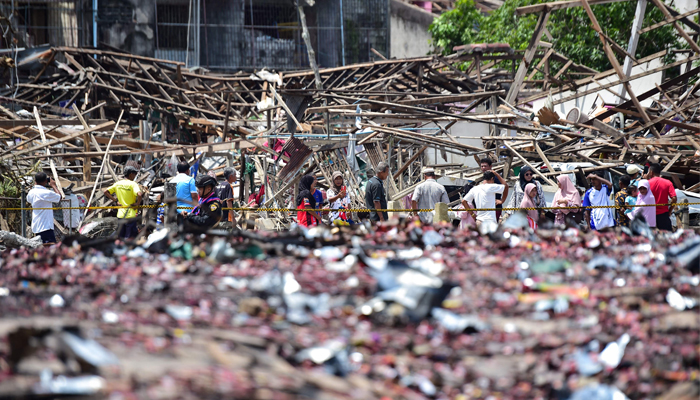 People look at the aftermath of destroyed homes the day after an explosion ripped through a firework warehouse in Sungai Kolok district Narathiwat province on July 30, 2023. — AFP