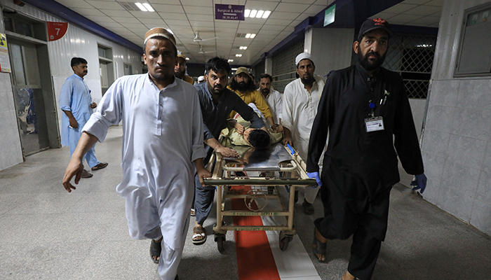 People transport a man, who was injured after a blast in Bajaur district of Khyber Pakhtunkhwa, at the Lady Reading Hospital in Peshawar, July 30. — Reuters