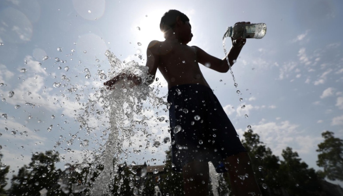 A young man cools himself with water in the sun. — Reuters/File