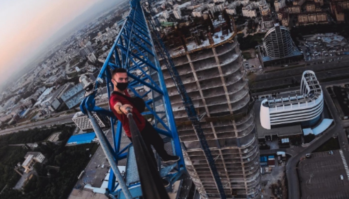 Remi stands atop a highrise building in this photo. — Instagram/remnigma