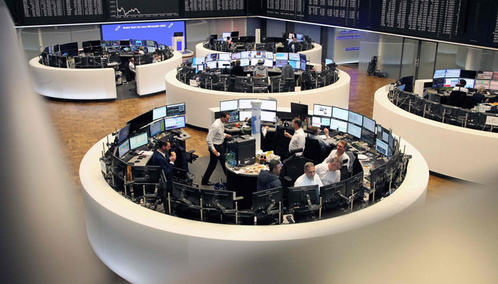 Brokers work at the stock exchange in Frankfurt, Germany on December 30, 2022. — AFP