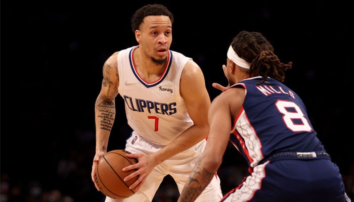 Amir Coffey #7 of the Los Angeles Clippers is guarded by Patty Mills #8 of the Brooklyn Nets during the first quarter at Barclays Center on January 1, 2022, in New York City. — AFP