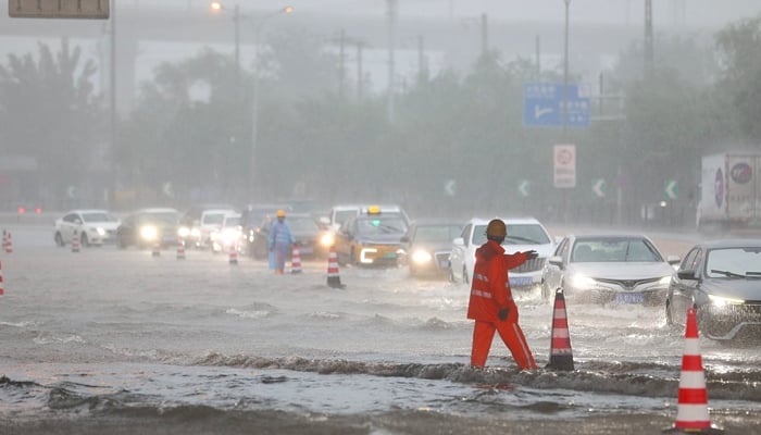 A rescue official can be seen in a submerged road in Beijing after torrential rain in the Chinese capital city, in this picture on August 1, 2023. — Twitter/@CTGN