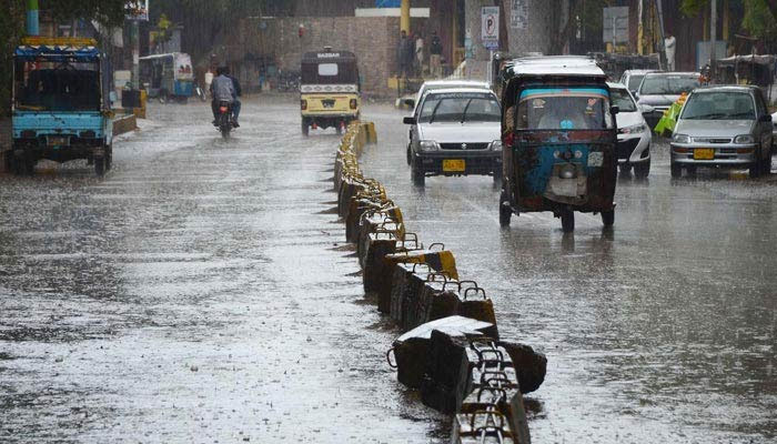 Vehicles passing through rain water during the heavy rain in Karachi on March 24, 2023. — INP/File
