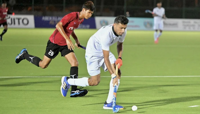 Hanan Shahid (R) moves the ball forward during a hockey match. — PHF