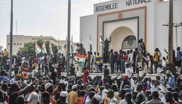 Supporters wave Nigeriens flags as they rally in support of Niger´s junta in front of the National Assembly in Niamey on July 30, 2023. — AFP