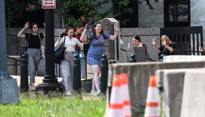 People walk out of the Russell Senate Office Building with their hands in the air on Wednesday. AFP