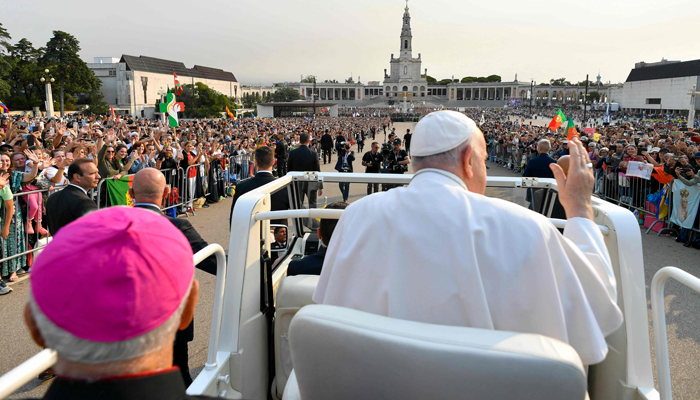 In this handout picture taken and released on August 5, 2023, by Vatican Media, Pope Francis arrives for the Holy Rosary prayer with sick young people at the Chapel of Apparitions in the Sanctuary of Our Lady of Fatima, in Fatima. — AFP