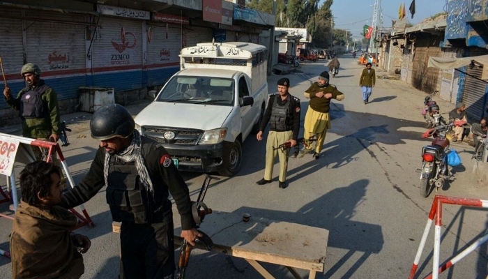 Police stand guard along a road they blocked after Taliban militants seized a police station in Bannu on December 19, 2022. — AFP
