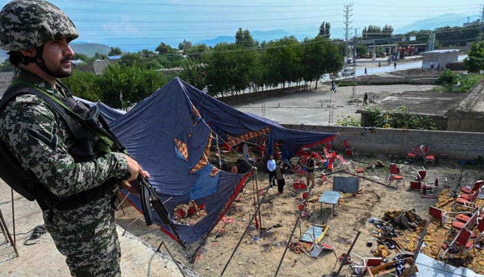 A security personnel stands guard next to the site of a bomb blast in Bajaur district of Khyber-Pakhtunkhwa province on July 31, 2023. — AFP