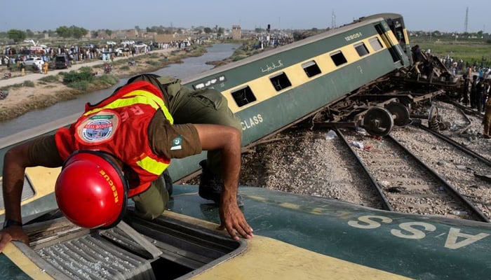 A rescue worker searches for victims after a train derailed in Sarhari town in district Sanghar, Pakistan August 6, 2023. — Reuters