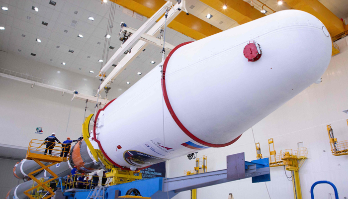 This photo taken on August 7, 2023, shows technicians finishing assembling a Soyuz 2.1b rocket carrying the Luna-25 lander at the Vostochny cosmodrome, in the Amur region. — AFP