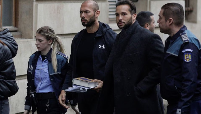 Andrew Tate and his brother Tristan are escorted by police officers outside the headquarters of the Bucharest Court of Appeal, in Bucharest, Romania, on January 10, 2023. — Reuters