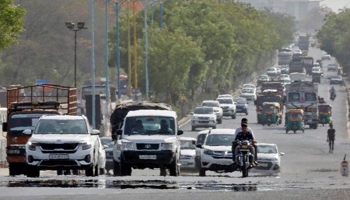 Traffic moves on a road in a heat haze during hot weather on the outskirts of Ahmedabad, India, May 12, 2022. — Reuters