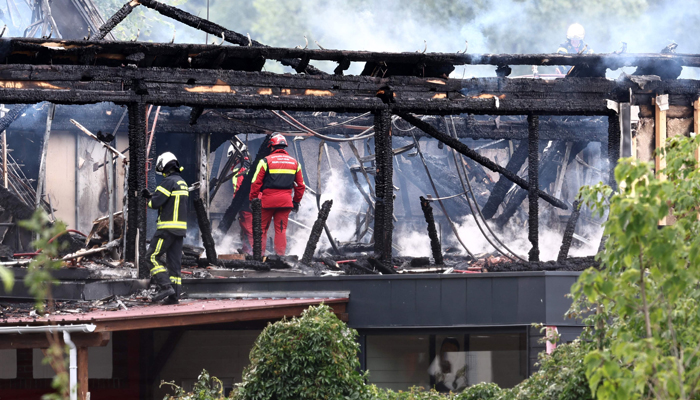 Firefighters inspect a burnt building after a fire erupted at a holiday home for disabled people in Wintzenheim, eastern France, on August 9, 2023. — AFP