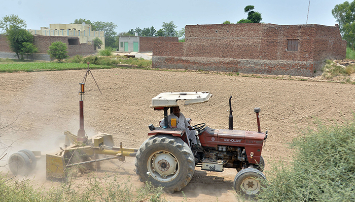 A farmer is busy in the cultivation of fields along the Sumandari road in Faisalabad, on June 22, 2023. — Online