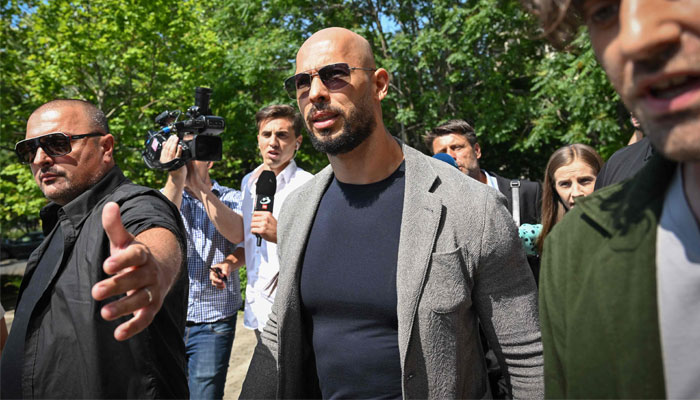 Controversial influencer Andrew Tate (C) arrives at the Municipal Court of Bucharest, Romania, on June 21, 2023. — AFP