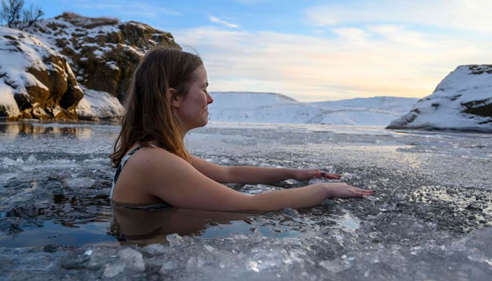 A woman bathes in the waters of an ice-covered lake in southwestern Iceland. — AFP/File