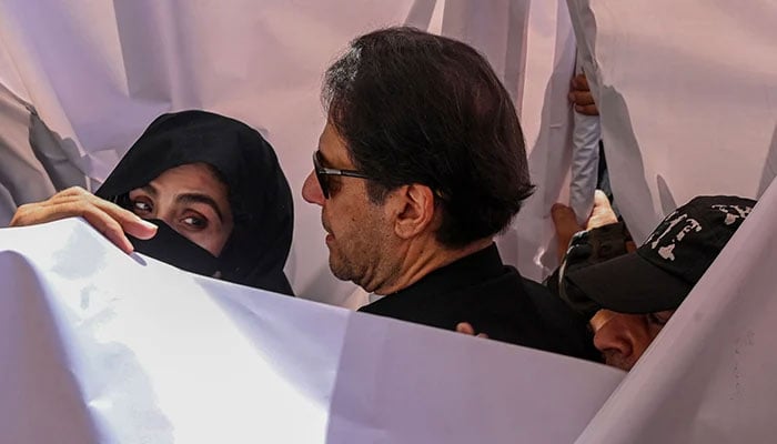 Former prime minister Imran Khan (centre) with his wife Bushra Bibi (left) arrive to appear at a high court in Lahore on May 15, 2023. — AFP