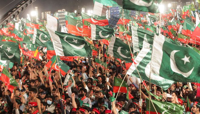 Supporters of the Pakistan Tehreek-e-Insaf (PTI) wave flags as they gather to listen to the speech of the ousted Pakistani Prime Minister Imran Khan during a rally, in Lahore on April 21, 2022. — Reuters